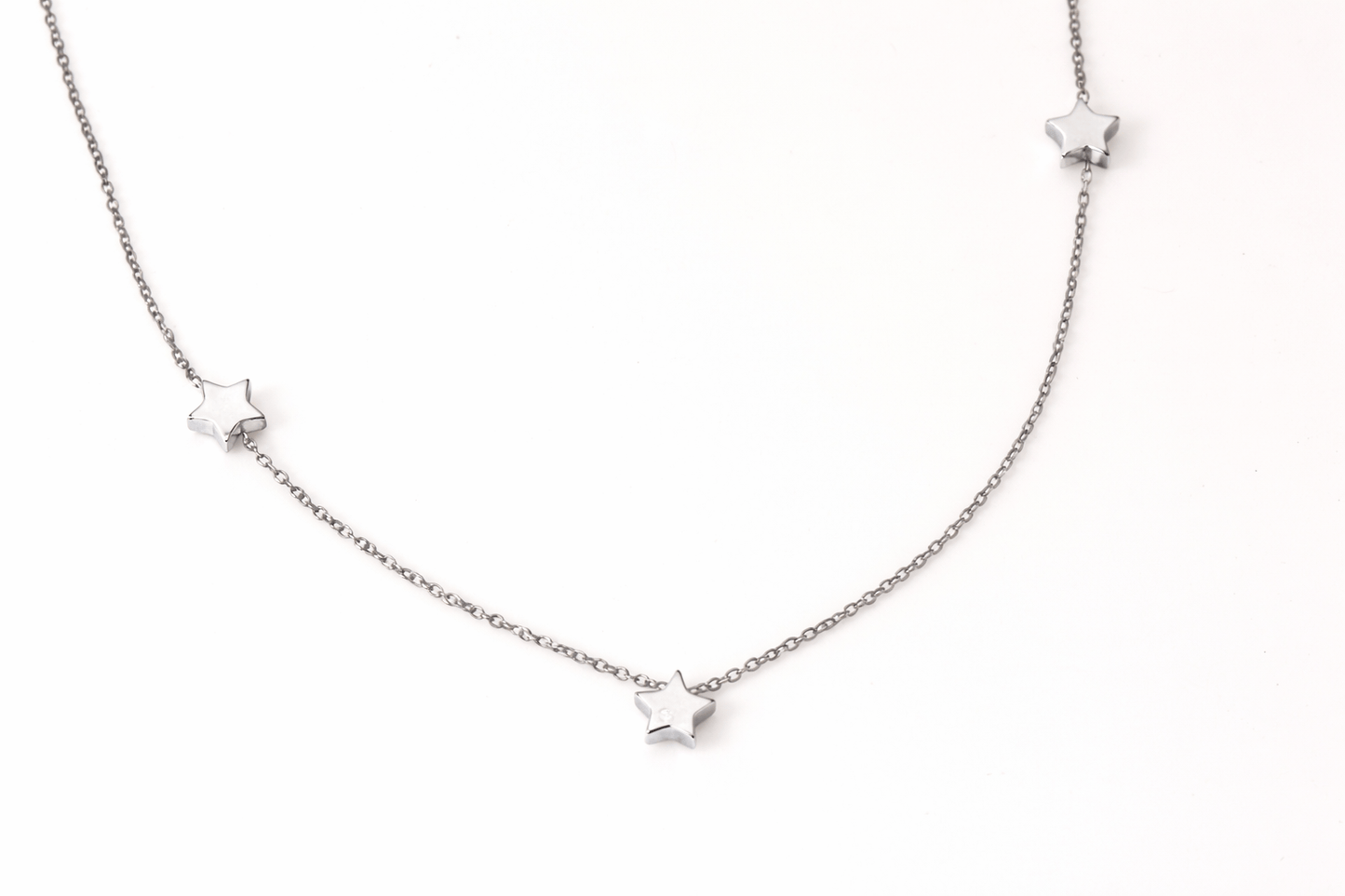 Silver necklace with star pendants on a white background