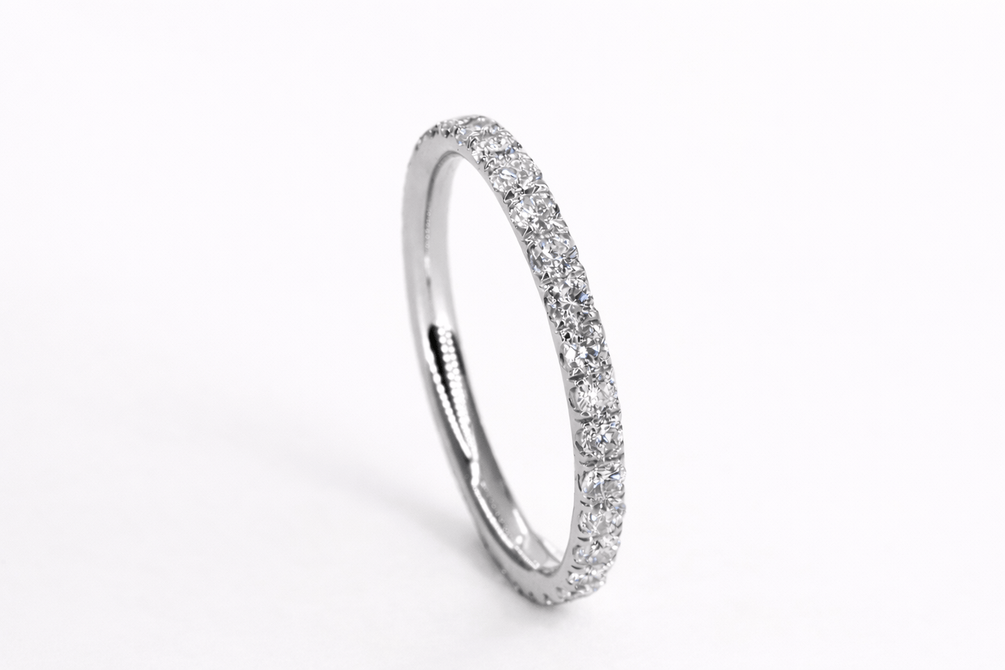 Silver ring with small diamonds on a white background