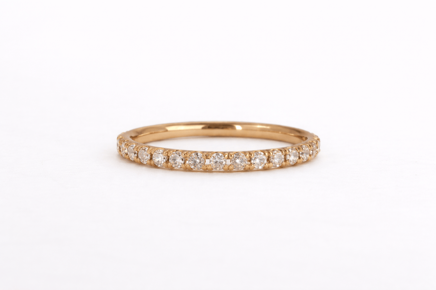 Rose gold ring with small diamonds on a white background