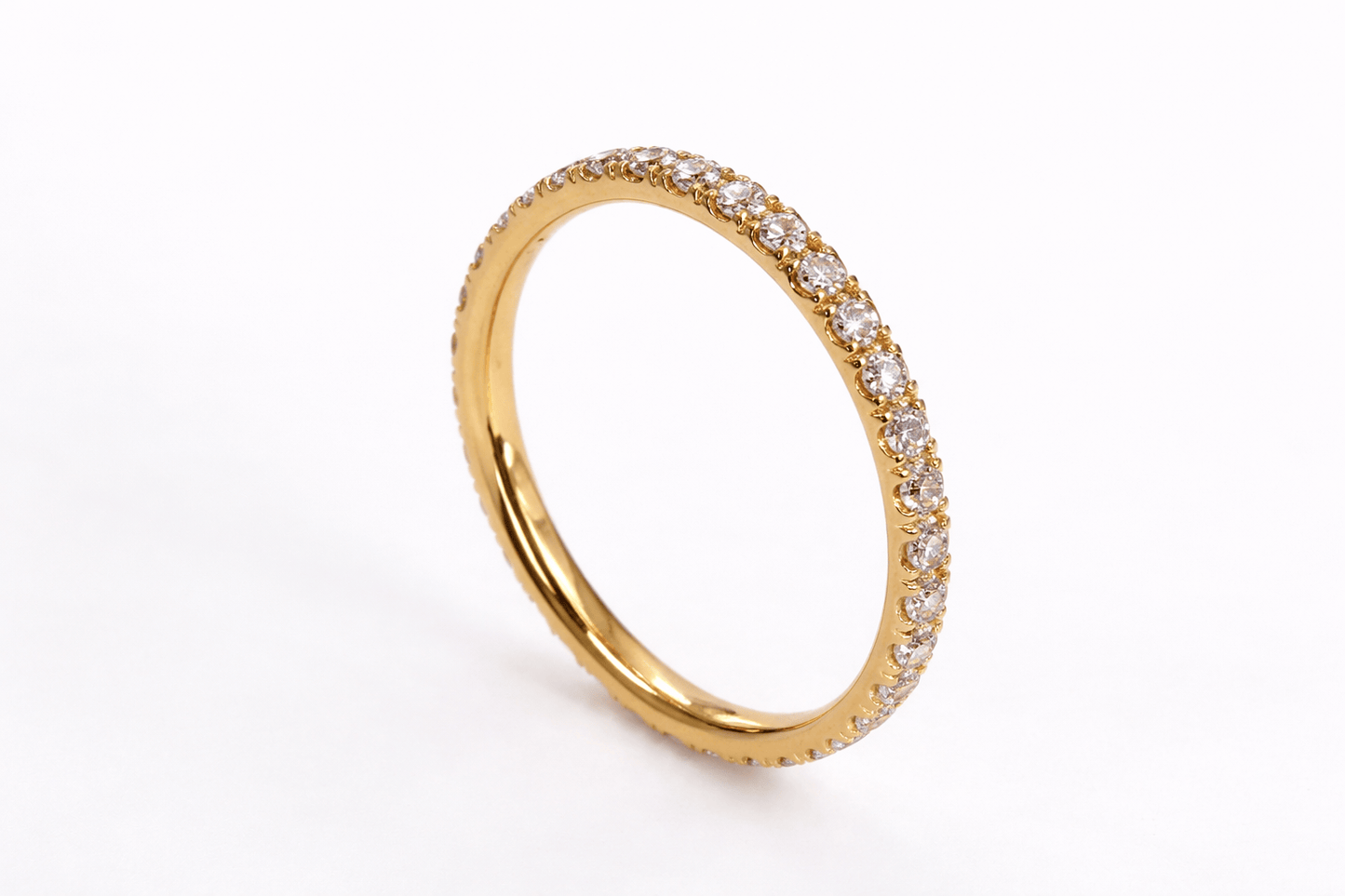 Gold ring with embedded diamonds on a white background