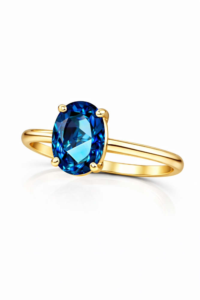 Gold ring with a blue gemstone on a white background