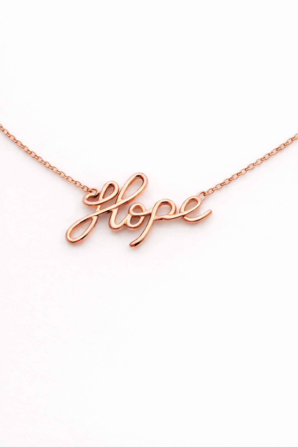 Rose gold 'hope' necklace on a white background