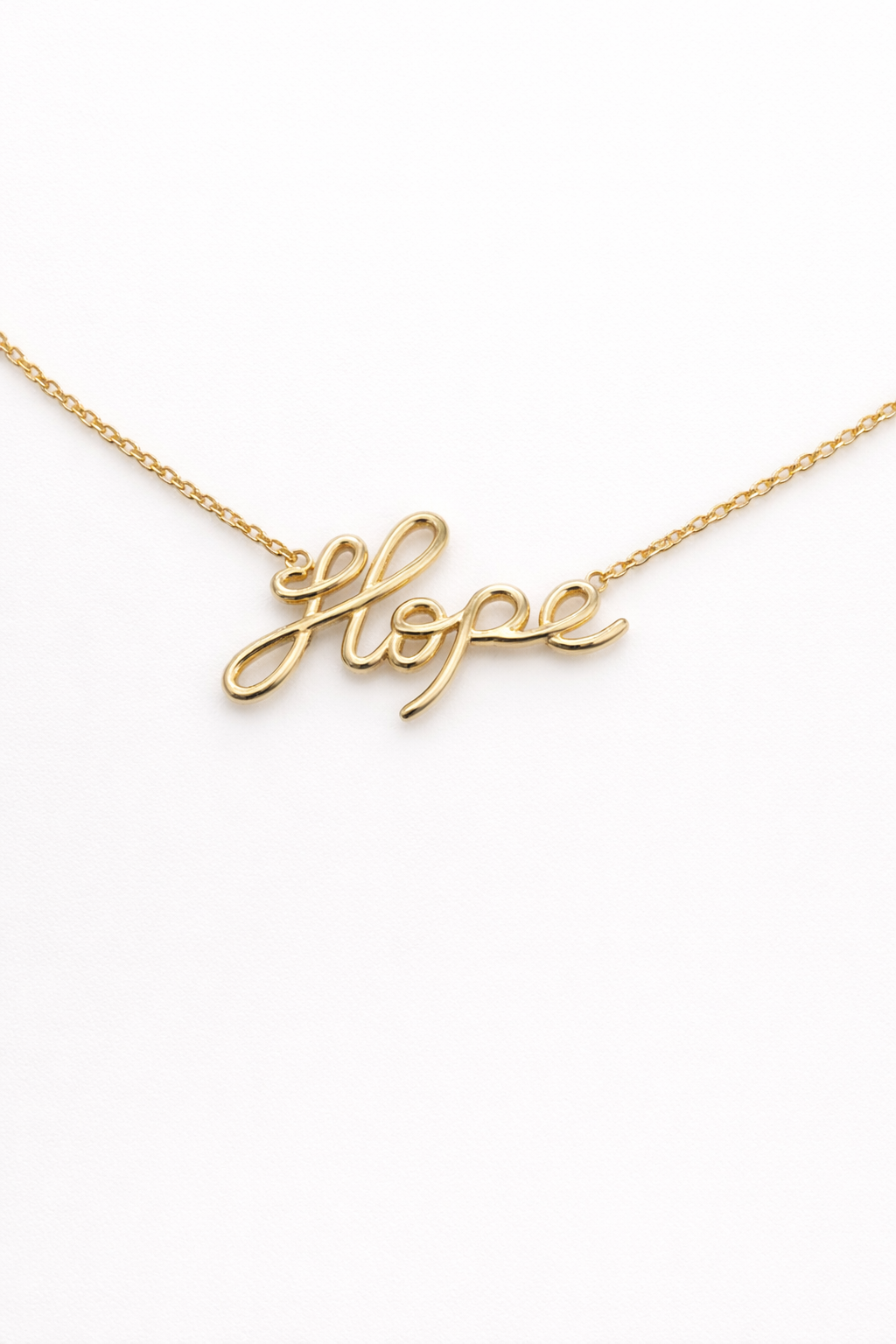 Gold necklace with 'hope' pendant on a white background