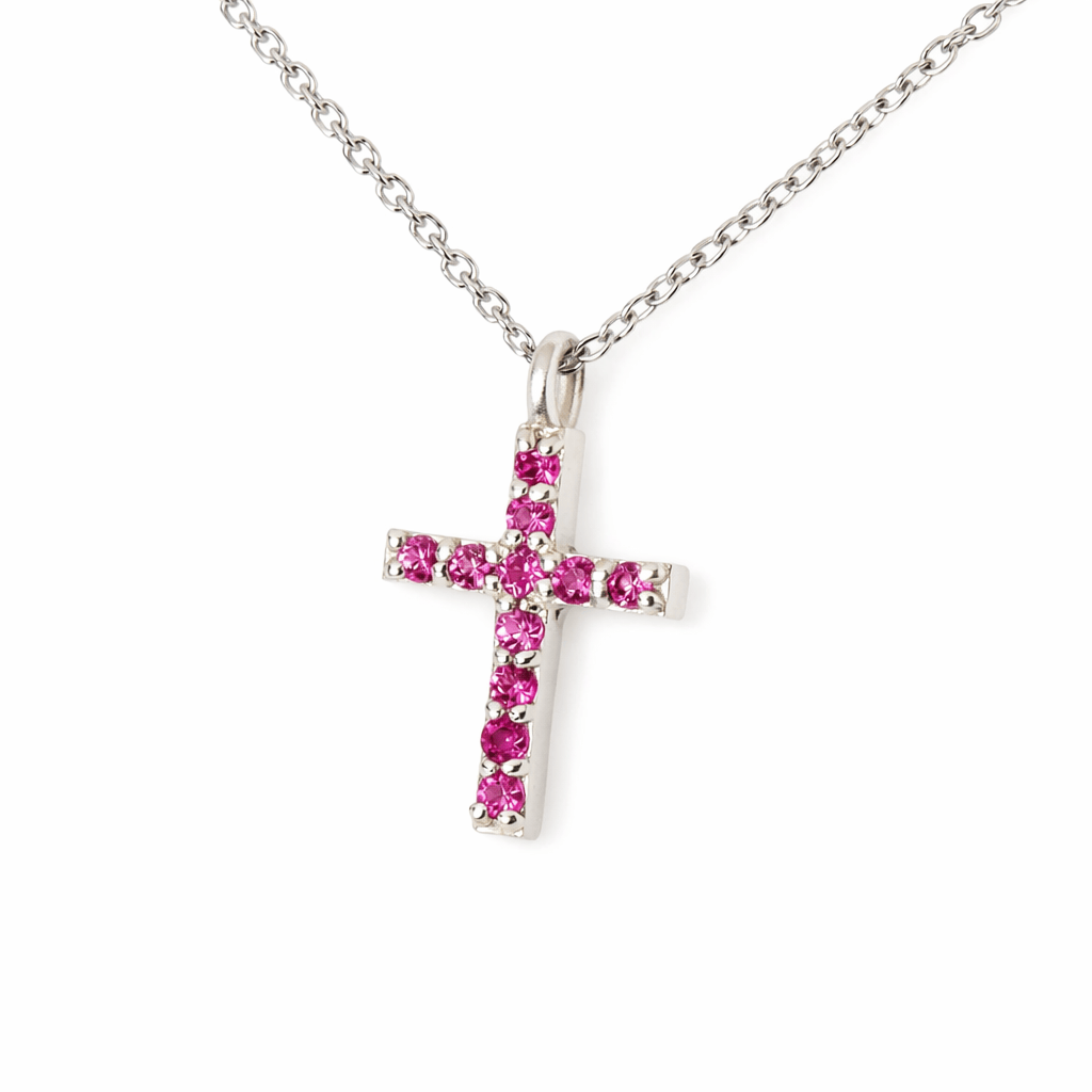 Silver cross pendant with pink gemstones on a white background