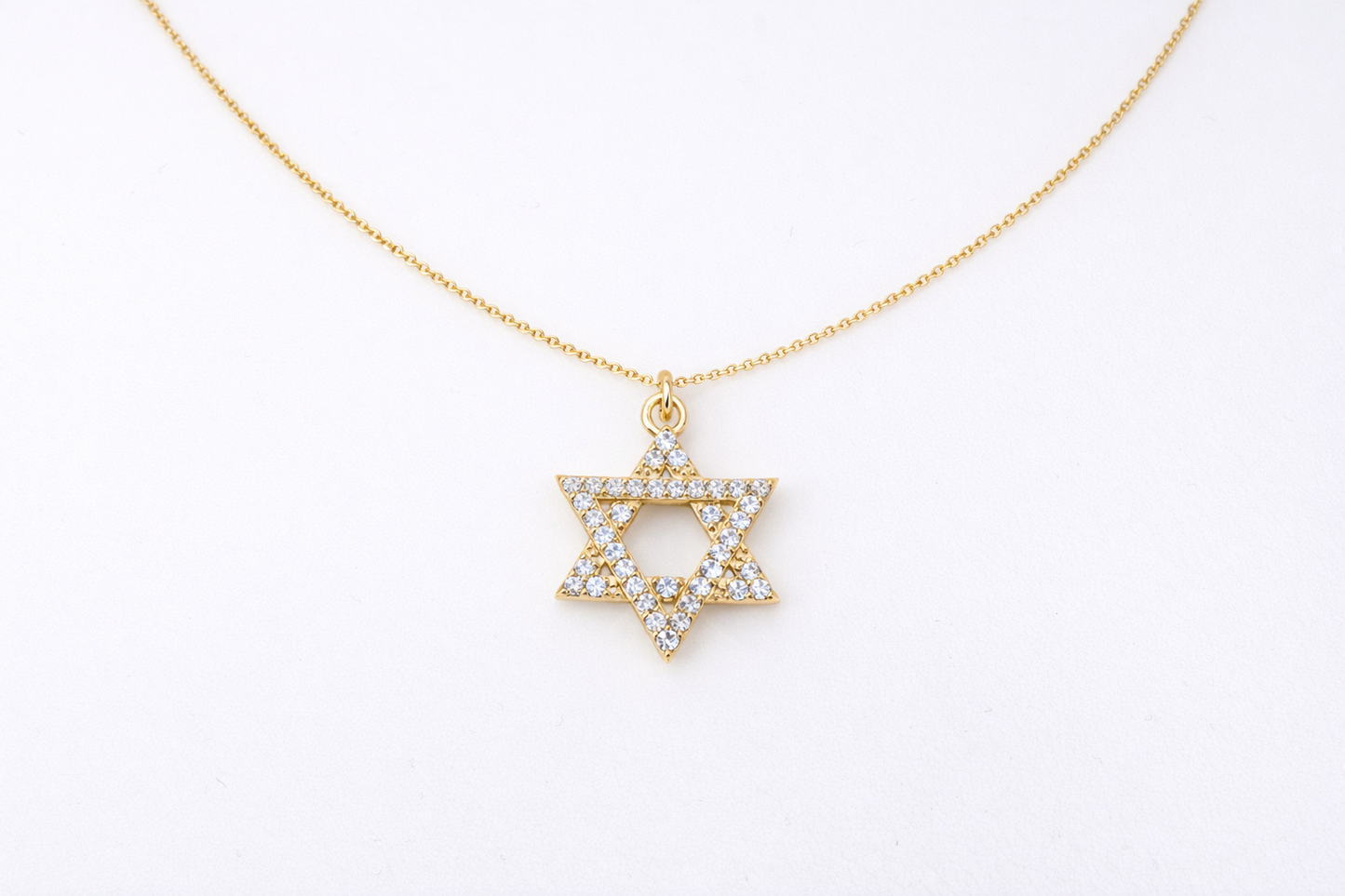 Gold necklace with a Star of David pendant on a white background